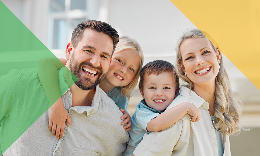 A family of four embrace and smile