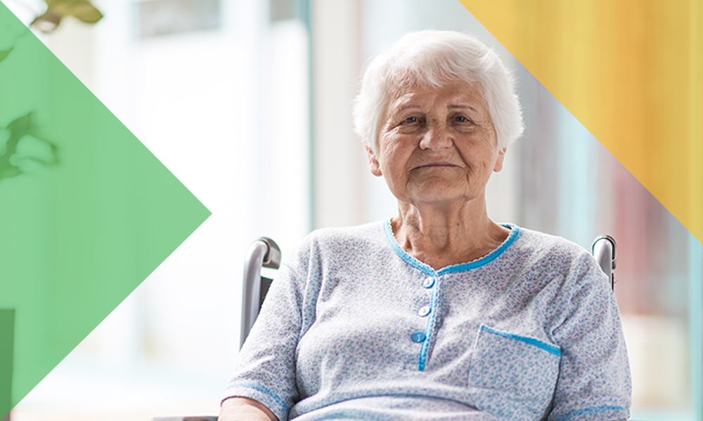 Senior woman in a wheelchair, sits in front of a window on a sunny day